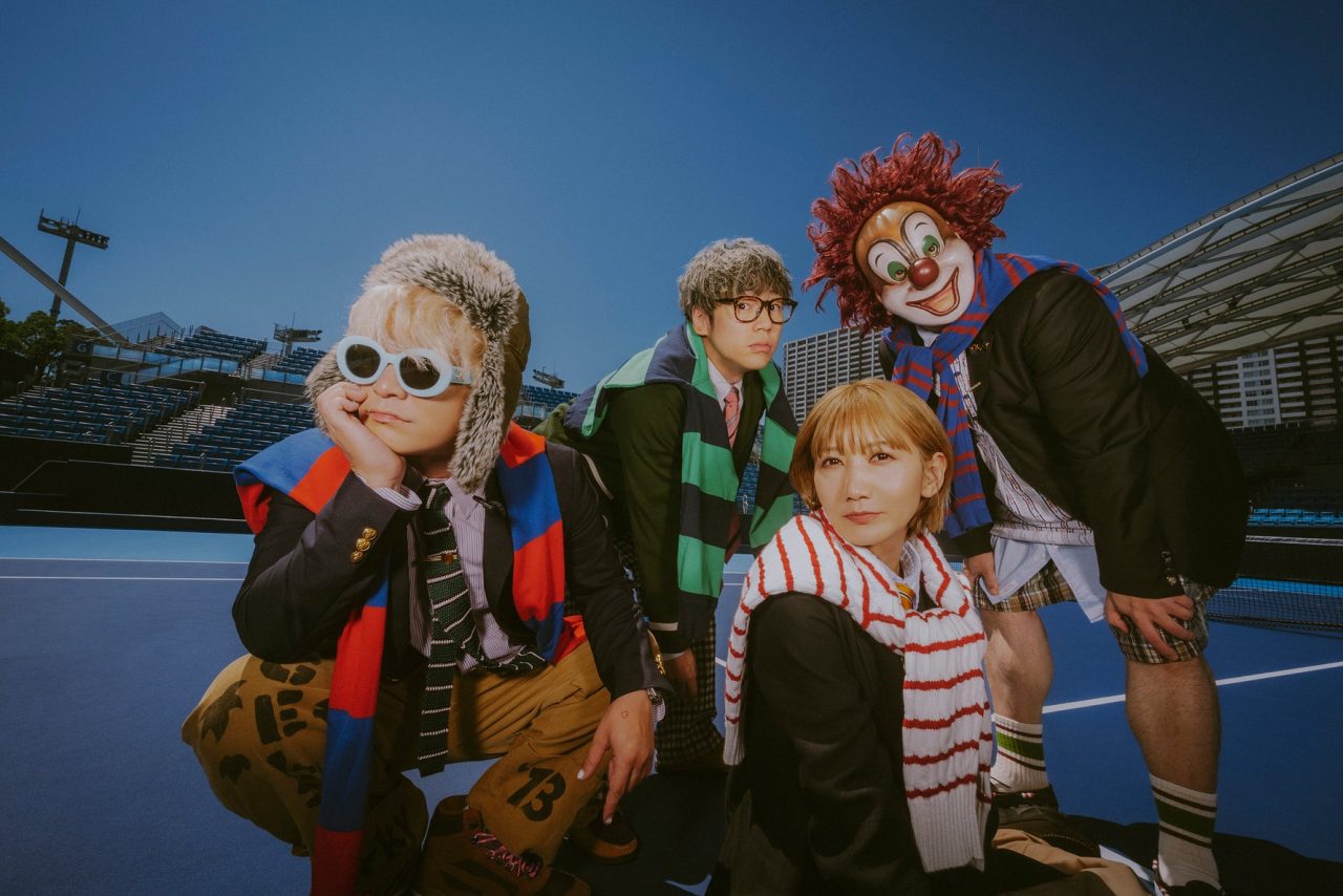 The four members of SEKAI NO OWARI pictured on a blue outdoor court